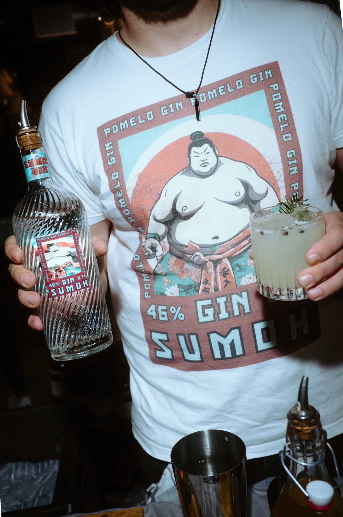 Sumoh Gin & Tonic im Glas an der Bar, daneben die Flasche Pomelo Gin